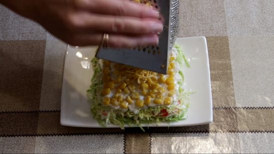 Добавляем кукурузу, яичные желтки и украшаем салат икрой